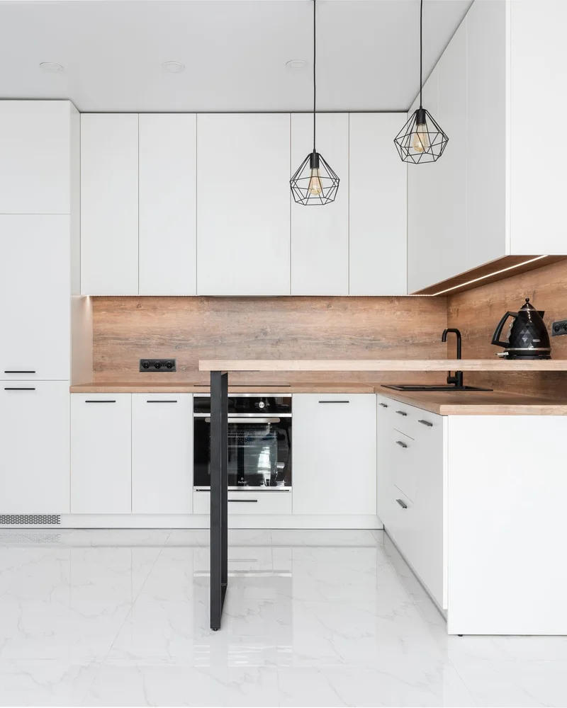 Modern white kitchen with wood accents.