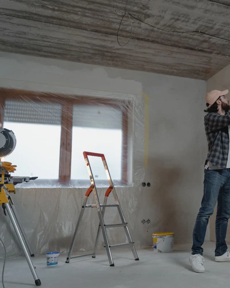 Painter rolling paint onto a wall.