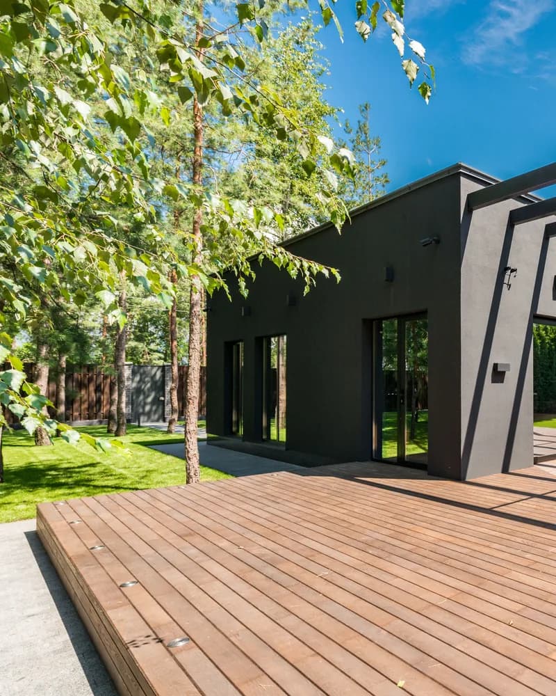Modern dark house exterior with a wood deck