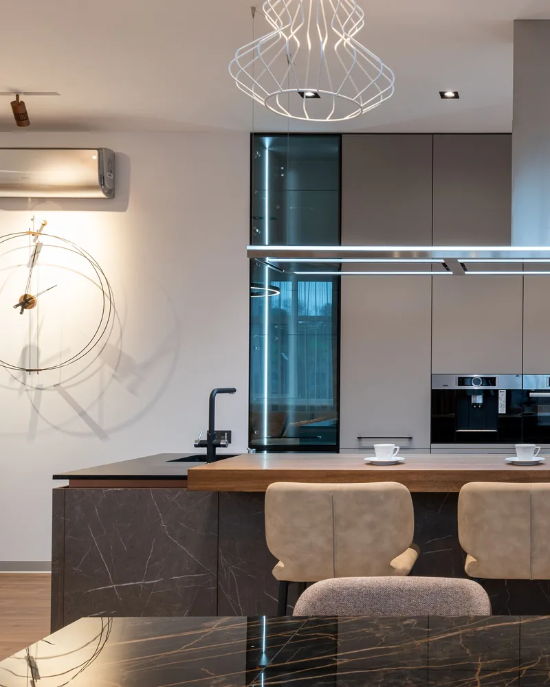 Modern kitchen with dark cabinetry and stone surfaces