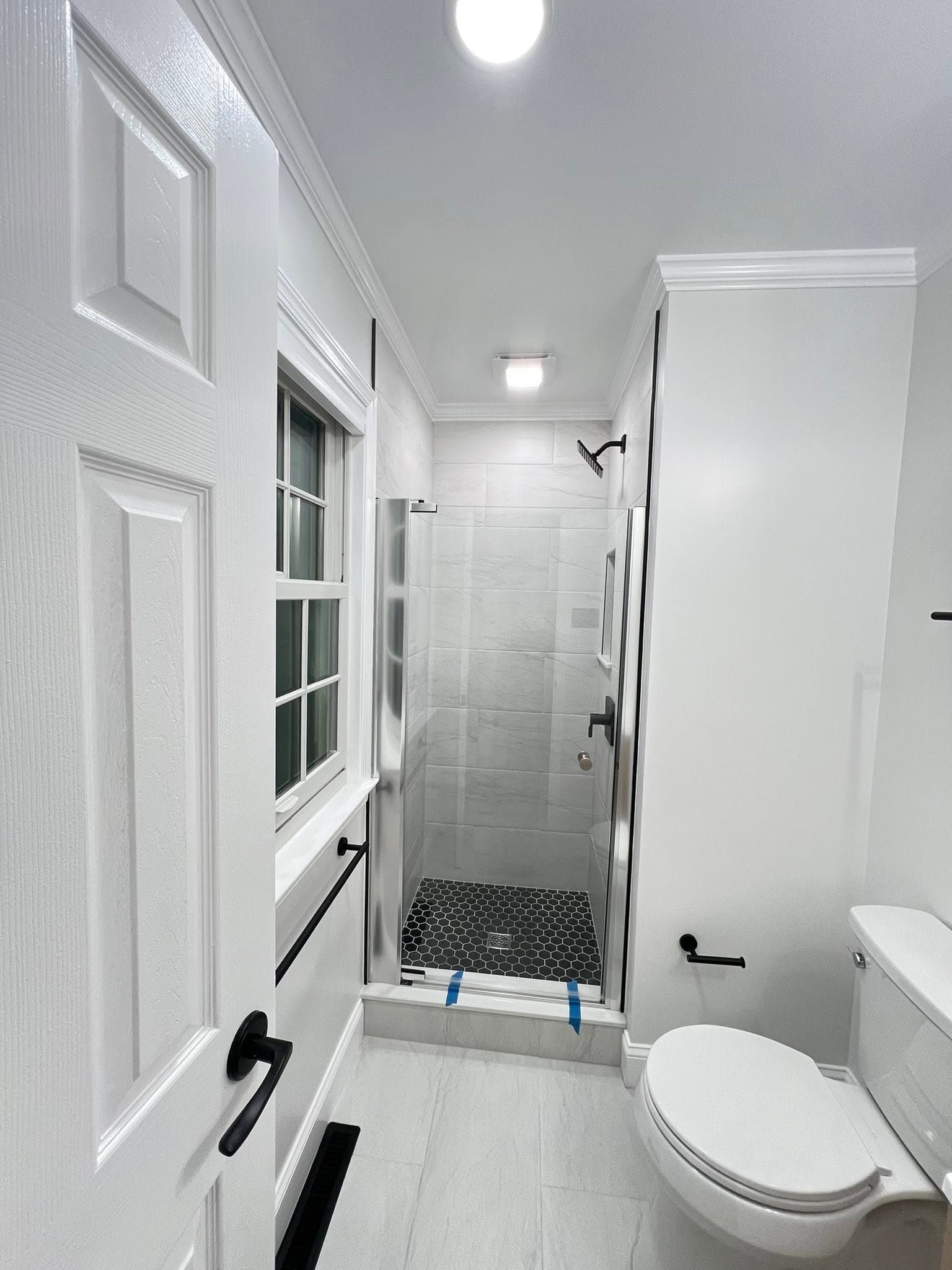 Compact bathroom with glass shower, after view 1